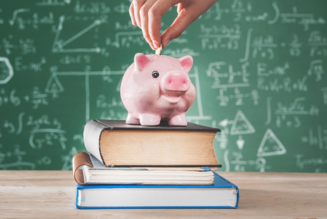 a pink piggy bank on a stack of books